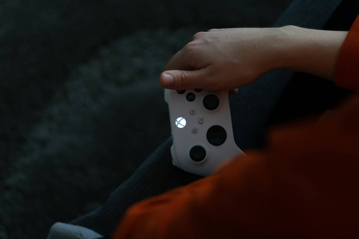 A person using a wireless remote to control a robotic pet toy outdoors.