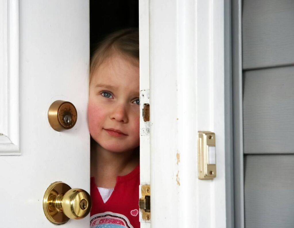 A little girl opening the door from inside.